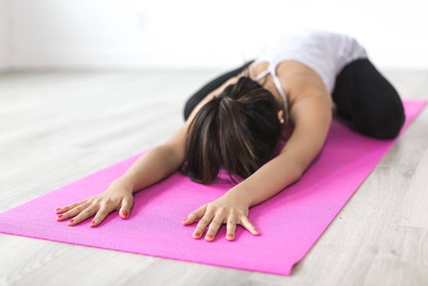 Vrouw in yoga houding op yoga mat