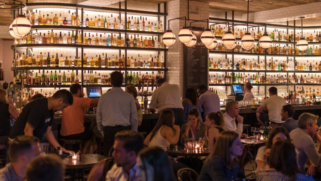 Drukke bar waar personeel en ambiance samen aandacht voor de gast centraal stellen